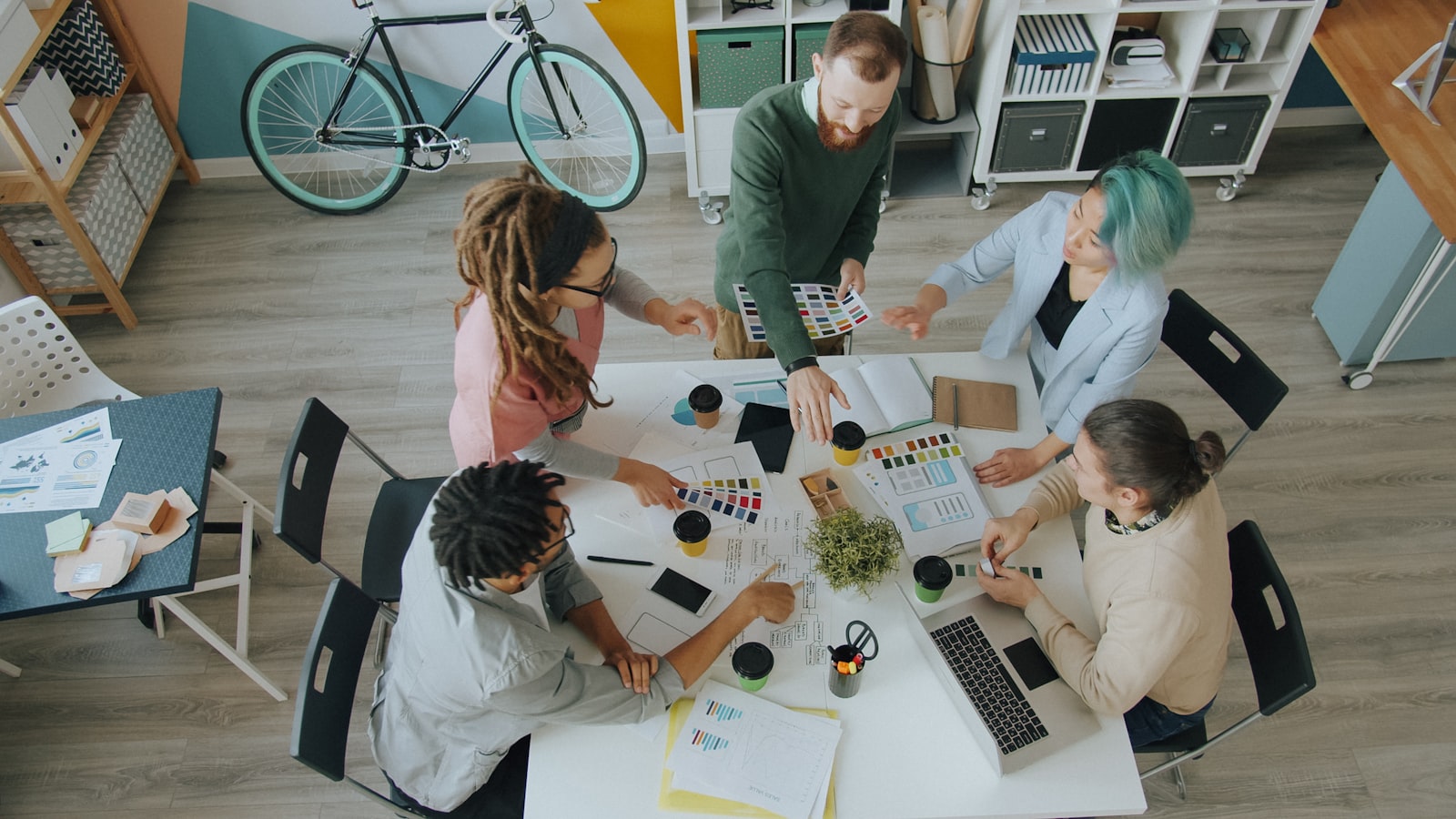 Overhead studio meeting, team gathered around a table